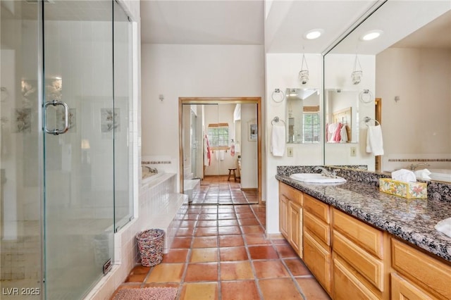 bathroom with double vanity, a sink, a shower stall, and a bath