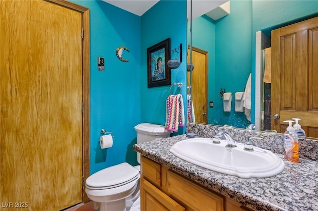 full bathroom with toilet and vanity