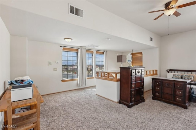 kitchen with a ceiling fan, open floor plan, visible vents, and light carpet