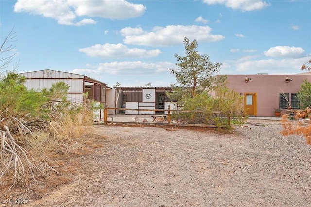 view of front of property with an outbuilding, an exterior structure, and stucco siding