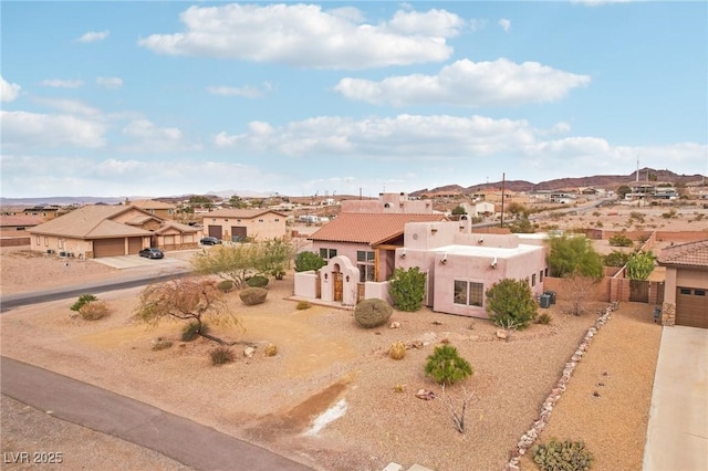 adobe home featuring a garage, a residential view, dirt driveway, and stucco siding