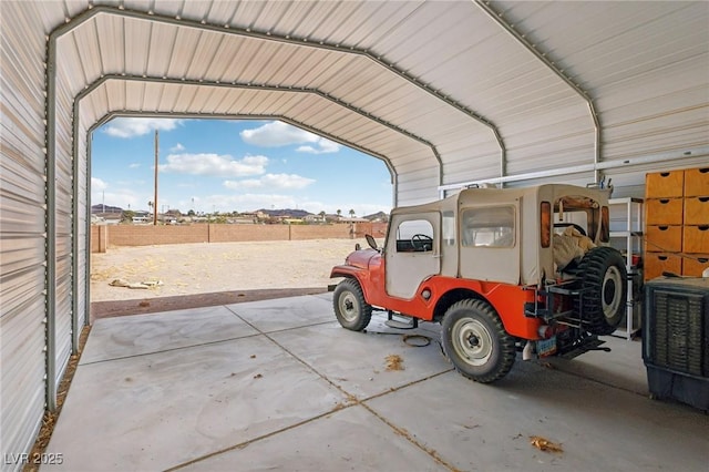 garage with fence and a detached carport