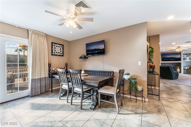 dining room featuring tile patterned flooring, visible vents, and ceiling fan