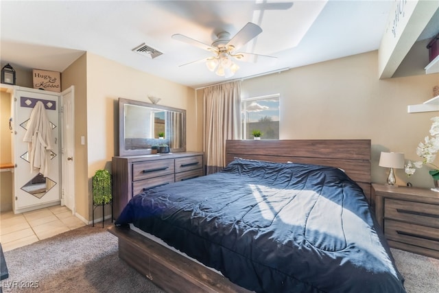 bedroom featuring baseboards, visible vents, a ceiling fan, tile patterned flooring, and carpet flooring