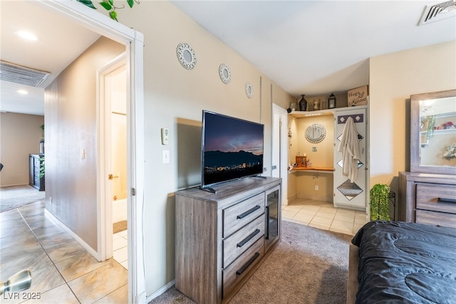 bedroom with visible vents, connected bathroom, and light tile patterned flooring