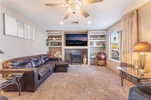 living room with carpet, recessed lighting, visible vents, a fireplace with raised hearth, and ceiling fan