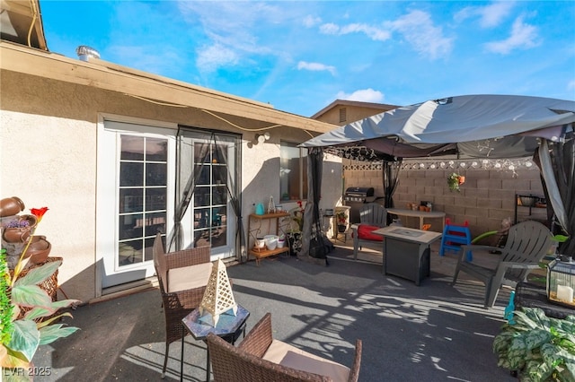 view of patio / terrace featuring an outdoor fire pit and fence