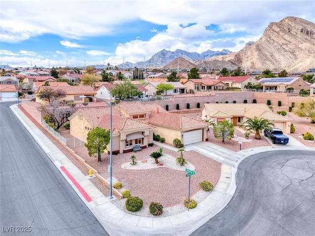 view of front facade featuring a mountain view, a tile roof, concrete driveway, a residential view, and stucco siding