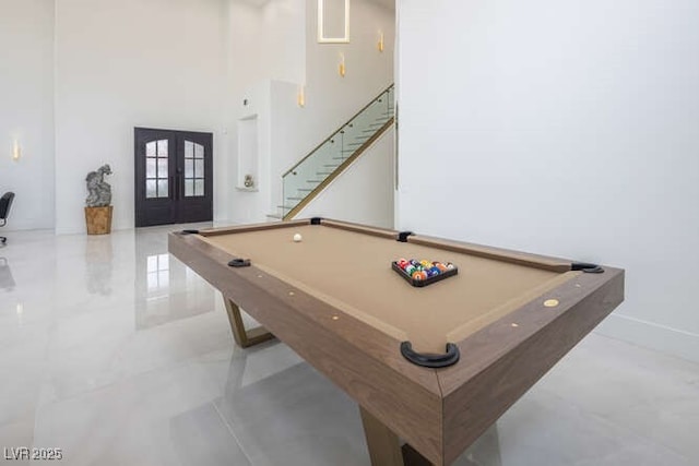 rec room with pool table, a high ceiling, baseboards, and french doors