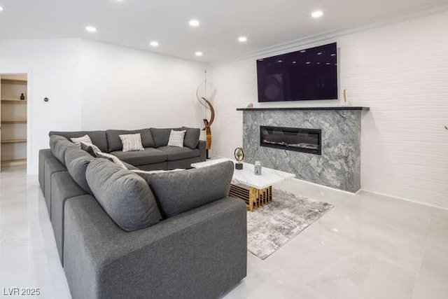 living room featuring marble finish floor, recessed lighting, and a high end fireplace