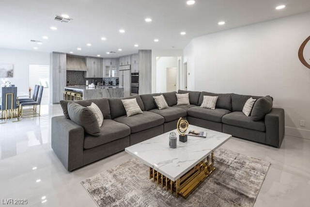 living room with baseboards, visible vents, and recessed lighting