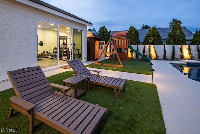 view of play area with a fenced in pool, a fenced backyard, a lawn, and a patio