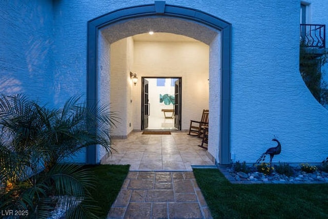 entrance to property featuring a patio and stucco siding