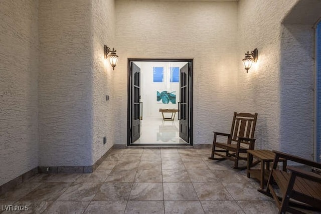 view of exterior entry with a patio and stucco siding