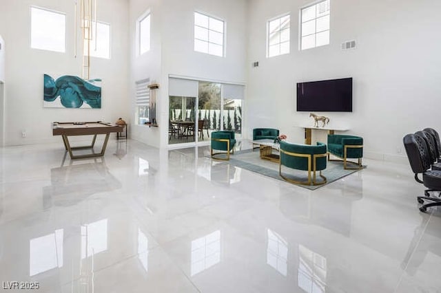 interior space featuring marble finish floor, visible vents, and a towering ceiling