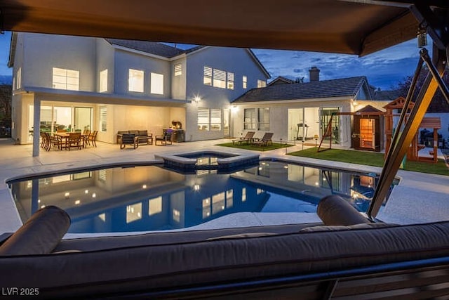 view of pool with a patio, an outdoor hangout area, a pool with connected hot tub, a playground, and outdoor dining space