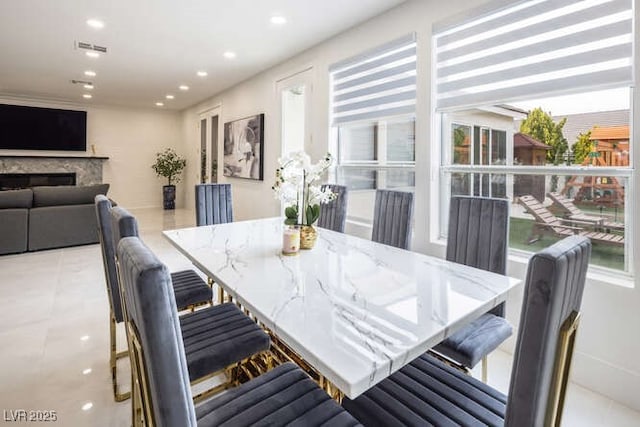 dining area with a fireplace, visible vents, and recessed lighting