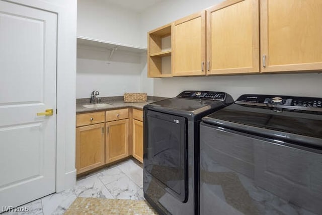 clothes washing area featuring marble finish floor, washer and clothes dryer, a sink, and cabinet space