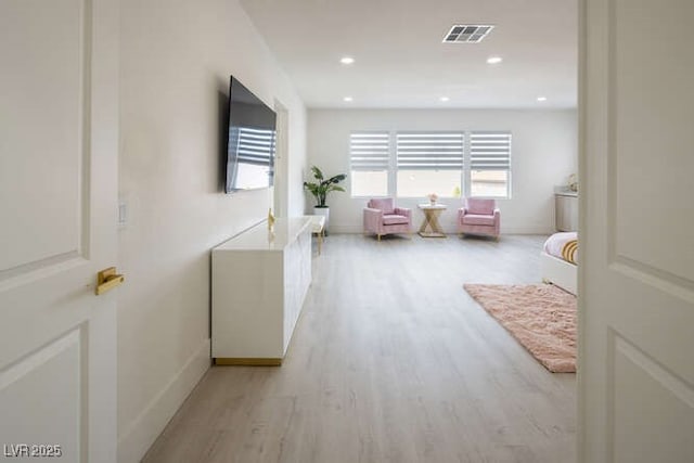 interior space featuring baseboards, light wood-type flooring, visible vents, and recessed lighting