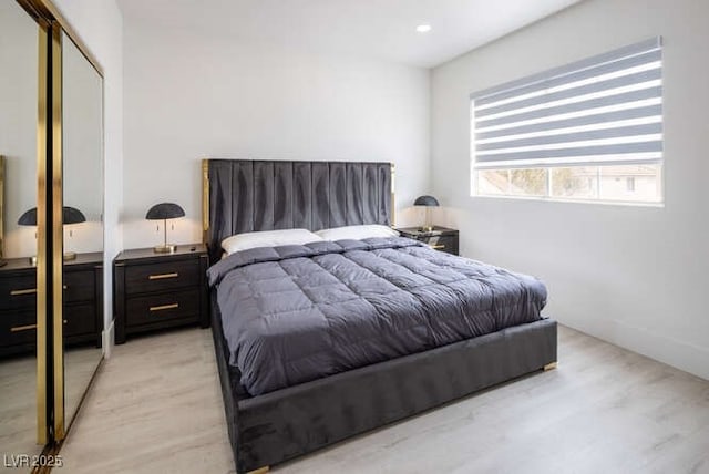 bedroom with a closet, recessed lighting, and light wood-style floors