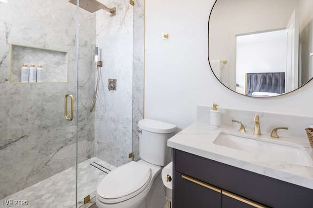 full bathroom with vanity, a marble finish shower, and toilet