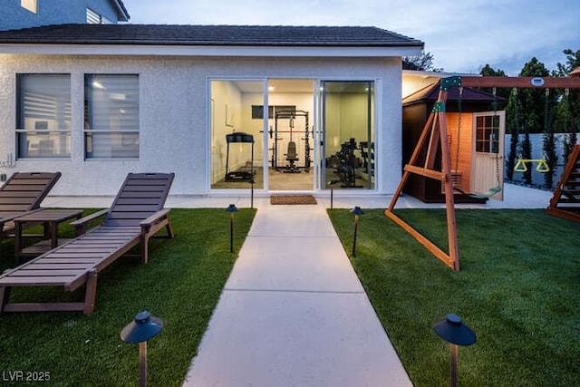 doorway to property featuring a yard and stucco siding