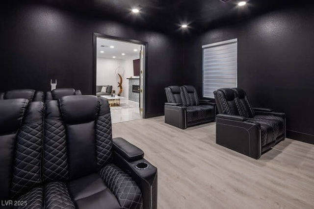 cinema room featuring a fireplace, wood finished floors, and recessed lighting