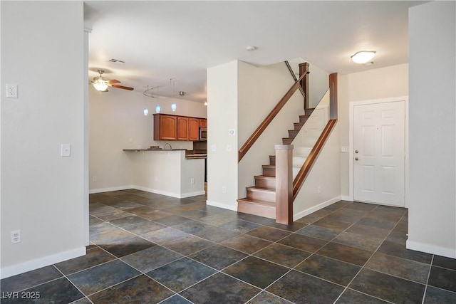 interior space with ceiling fan, stairway, visible vents, and baseboards