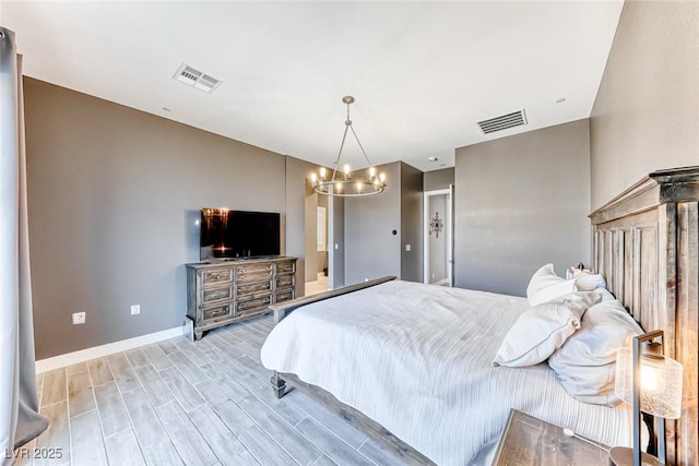 bedroom featuring light wood-style floors, baseboards, visible vents, and a notable chandelier