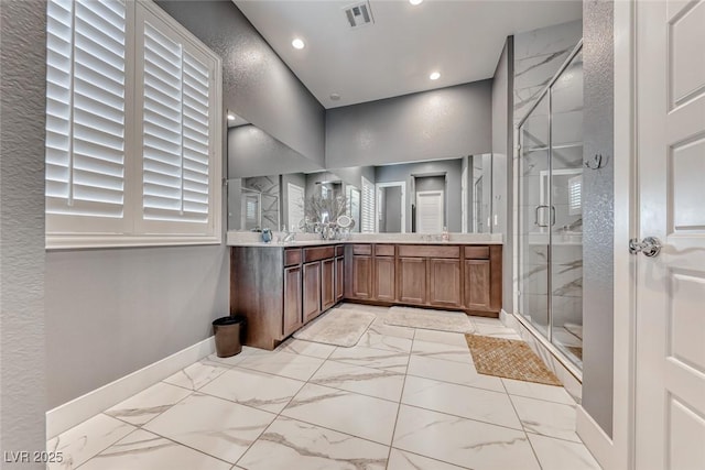 bathroom with visible vents, baseboards, marble finish floor, a shower stall, and double vanity