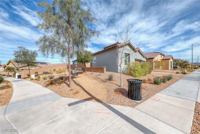 view of home's exterior featuring a tile roof, a residential view, and stucco siding