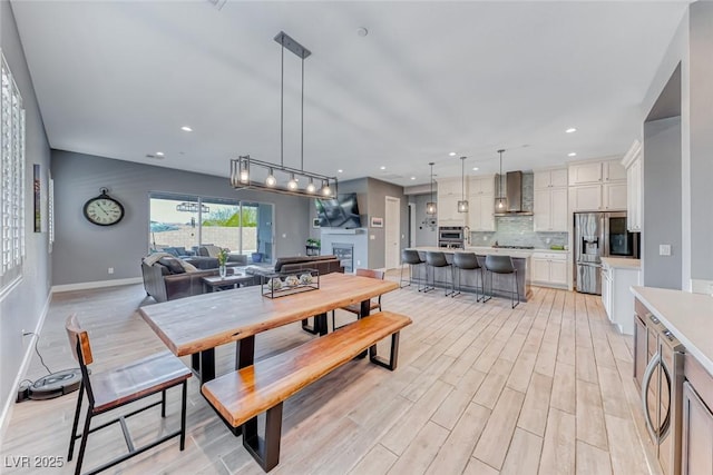 dining space with light wood-style flooring, baseboards, and recessed lighting