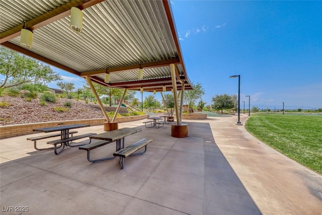 view of property's community featuring a patio area and a lawn