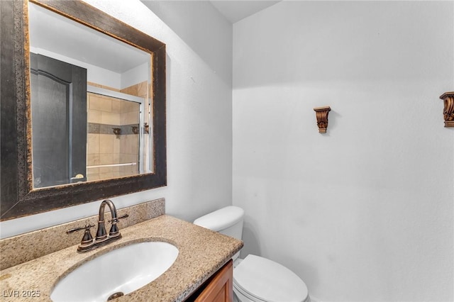 full bath with tiled shower, toilet, and vanity