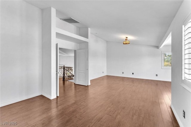 spare room with visible vents, baseboards, and wood finished floors