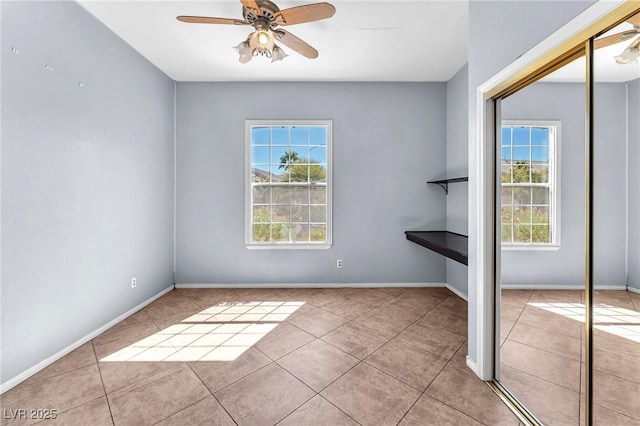 interior space with baseboards and ceiling fan