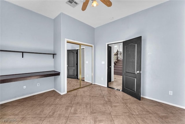 unfurnished bedroom with visible vents, a closet, tile patterned flooring, baseboards, and ceiling fan