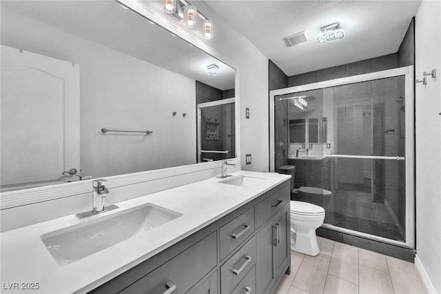 bathroom with double vanity, toilet, a stall shower, and a sink