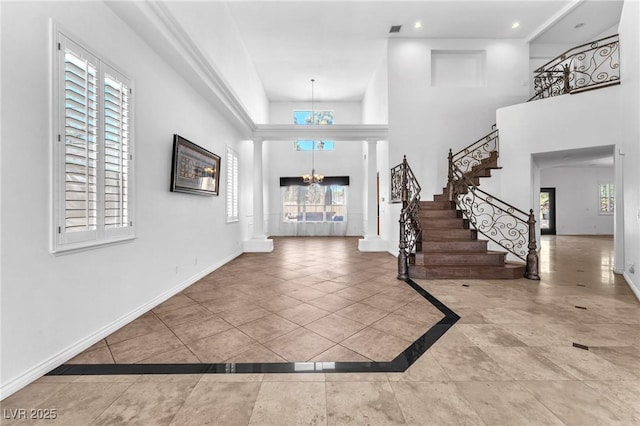 foyer entrance featuring a notable chandelier, a healthy amount of sunlight, stairway, and baseboards