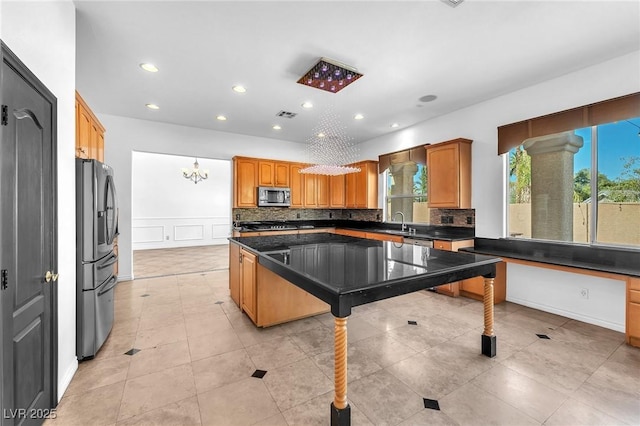 kitchen with decorative backsplash, plenty of natural light, appliances with stainless steel finishes, and a sink