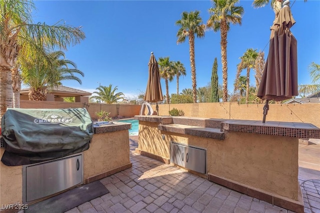 view of patio featuring area for grilling, a fenced in pool, and a fenced backyard