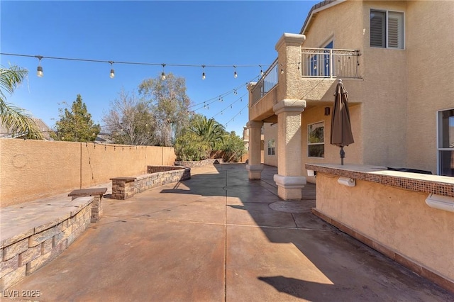 view of patio with a fenced backyard and a balcony