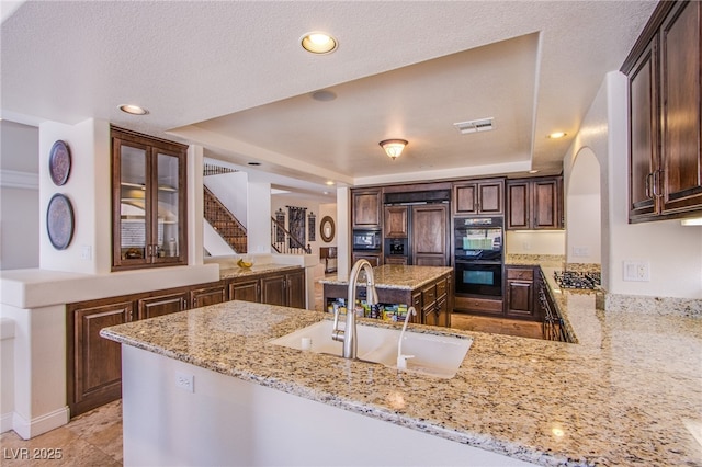 kitchen with visible vents, black appliances, a sink, a peninsula, and a raised ceiling