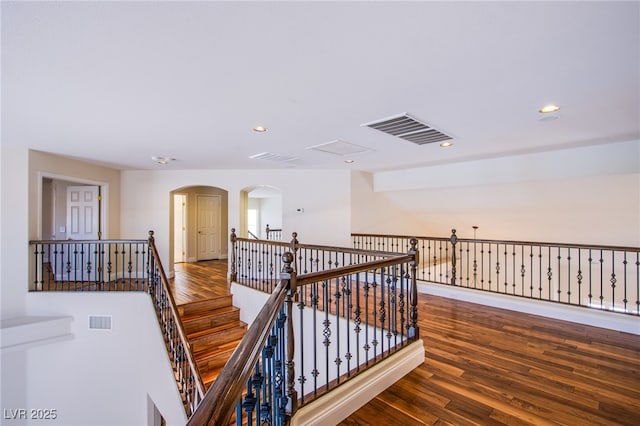 hall featuring an upstairs landing, visible vents, recessed lighting, and wood finished floors