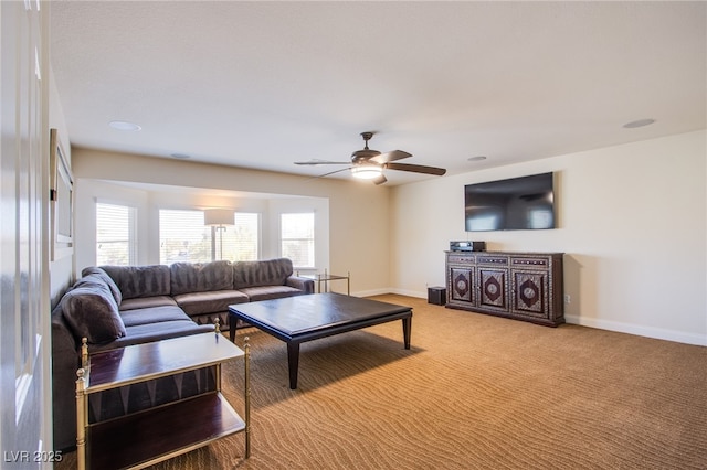 carpeted living room featuring ceiling fan and baseboards