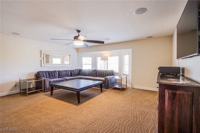 living room with visible vents, baseboards, light colored carpet, and ceiling fan