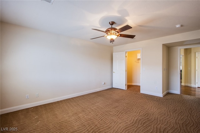 unfurnished bedroom with a spacious closet, a ceiling fan, carpet, and baseboards