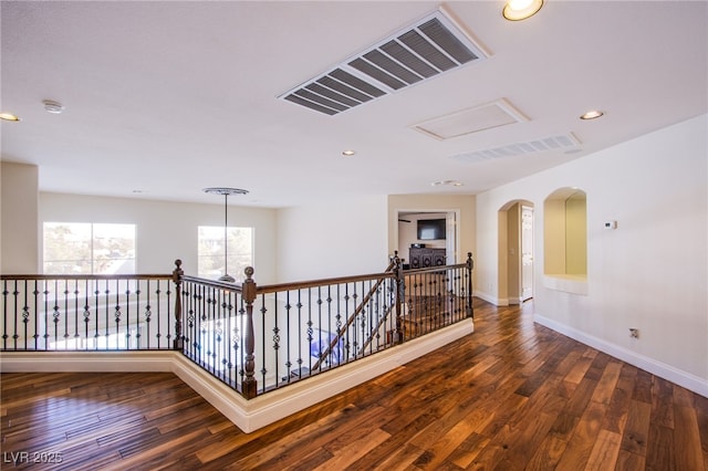 corridor with visible vents, recessed lighting, baseboards, and hardwood / wood-style flooring