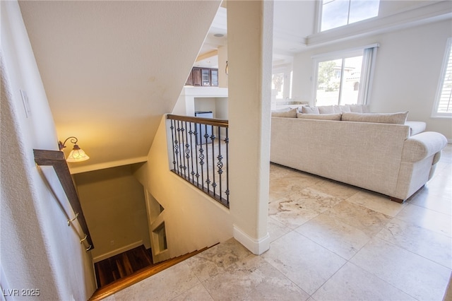 stairs featuring a high ceiling and baseboards