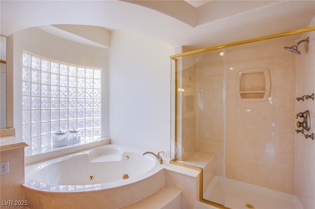 bathroom with a jetted tub and a stall shower